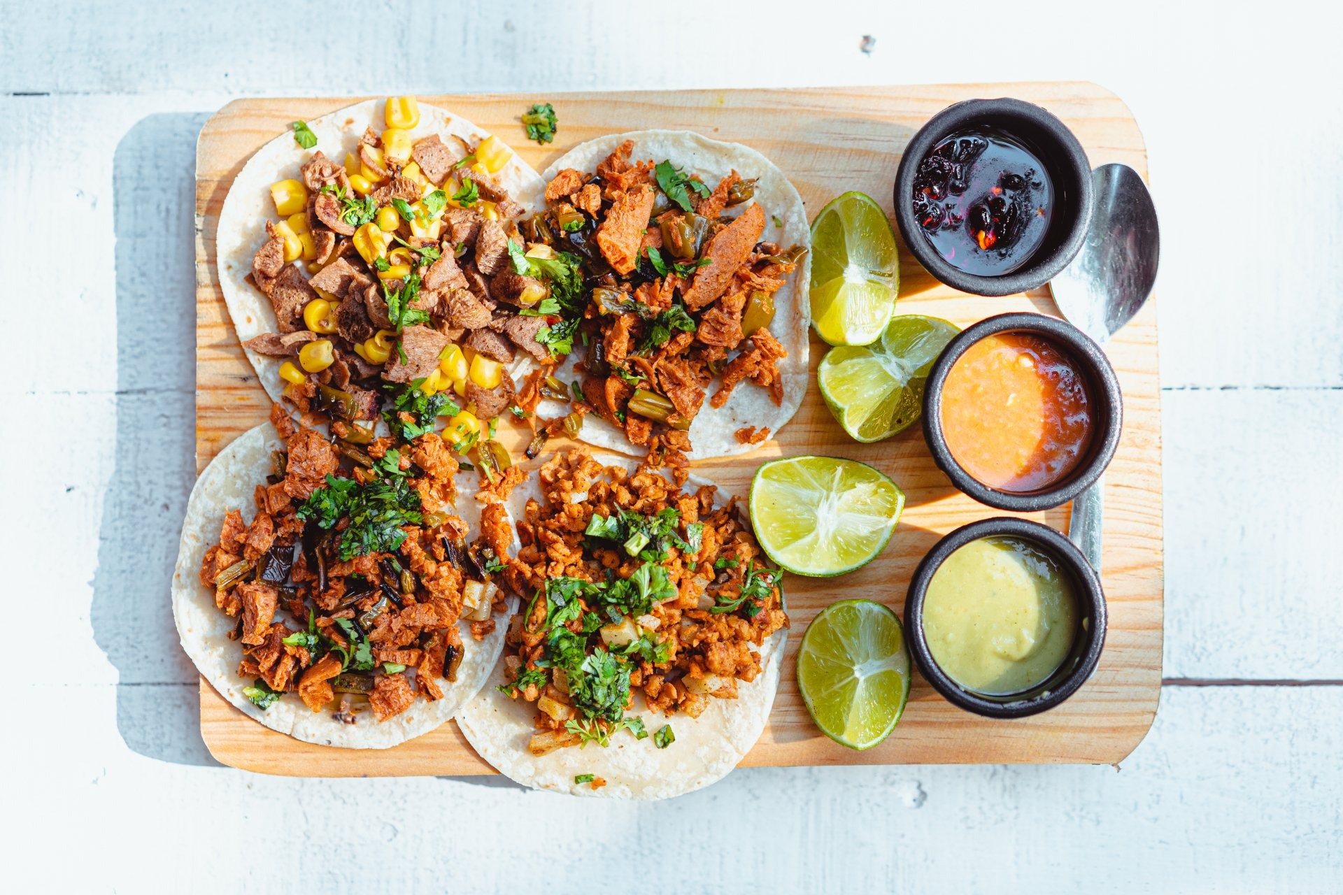 Sharing board of Mexican street tacos with three house salsas